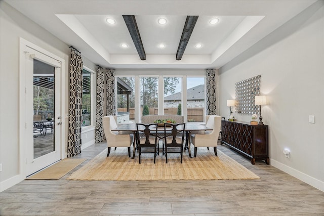 dining room with beamed ceiling and light hardwood / wood-style floors