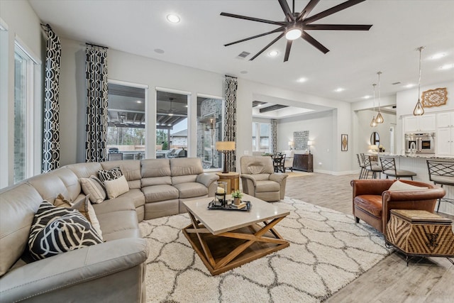 living room featuring light hardwood / wood-style floors and ceiling fan