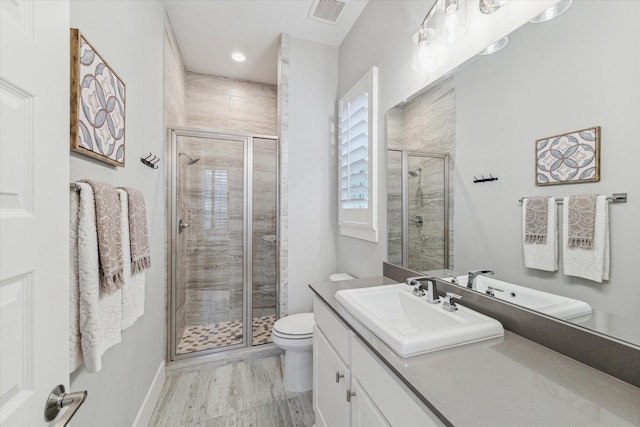 bathroom with vanity, toilet, and a shower with door