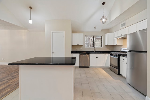 kitchen featuring stainless steel appliances, a center island, white cabinets, and decorative light fixtures