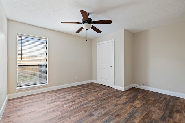 spare room with ceiling fan, dark hardwood / wood-style floors, and a textured ceiling