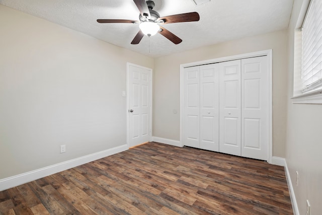 unfurnished bedroom featuring a closet, dark hardwood / wood-style floors, a textured ceiling, and ceiling fan