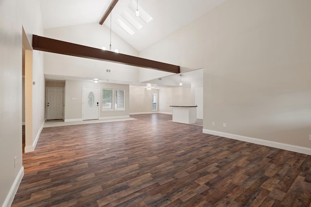 unfurnished living room with a skylight, beam ceiling, dark wood-type flooring, and high vaulted ceiling