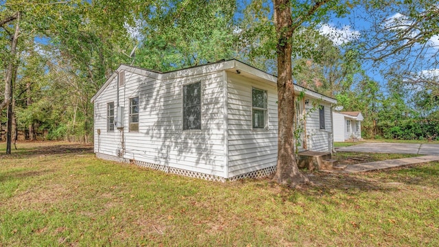 view of side of home with a yard