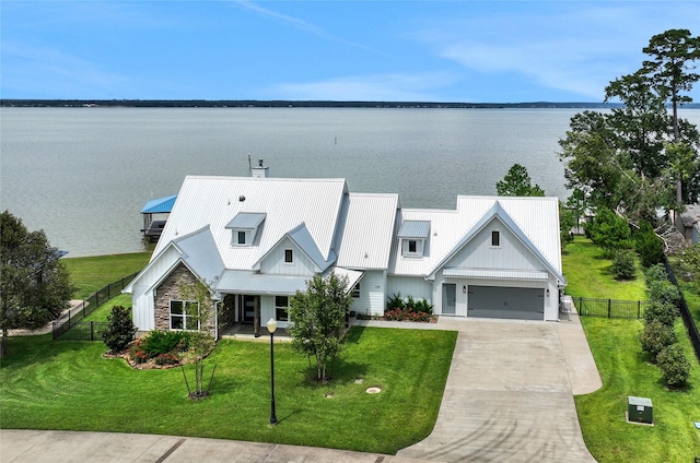 view of front of property with a garage, a water view, and a front yard