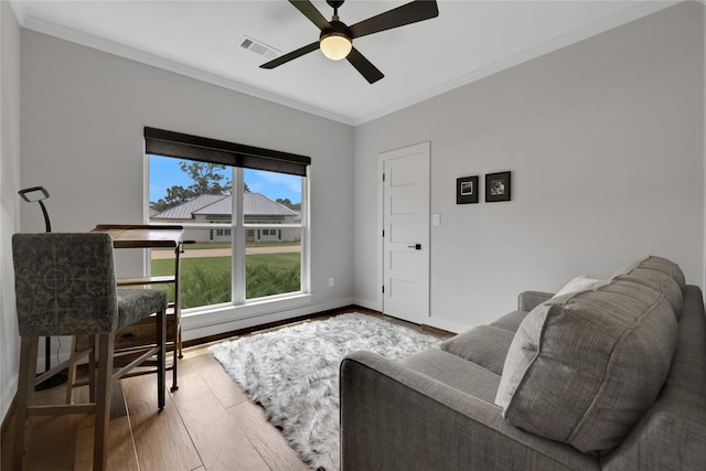 living room featuring crown molding, ceiling fan, and hardwood / wood-style floors