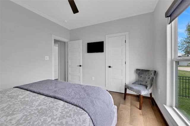 bedroom with crown molding, wood-type flooring, and ceiling fan