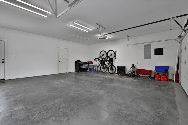 garage with a garage door opener and electric panel