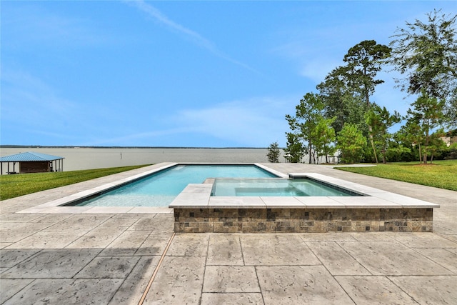 view of pool featuring an in ground hot tub, a water view, and a lawn