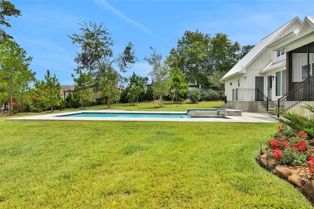 view of yard featuring a swimming pool with hot tub