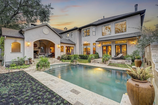 back house at dusk with a patio and ceiling fan