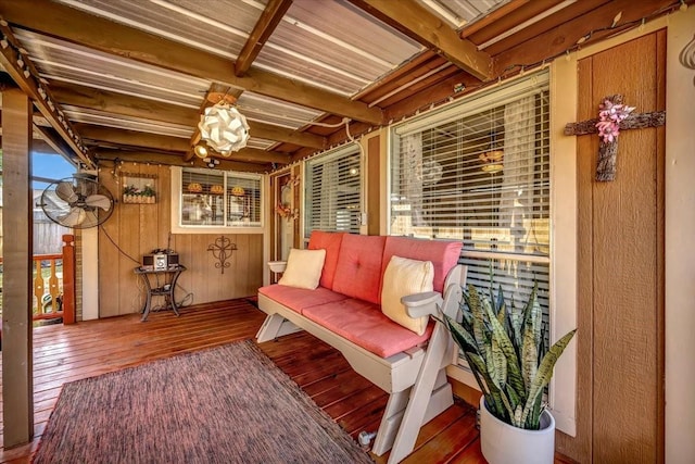 living area featuring beamed ceiling, wooden walls, and hardwood / wood-style flooring