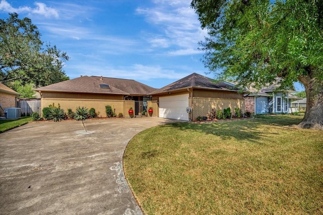 ranch-style home featuring a garage, a front yard, and central air condition unit