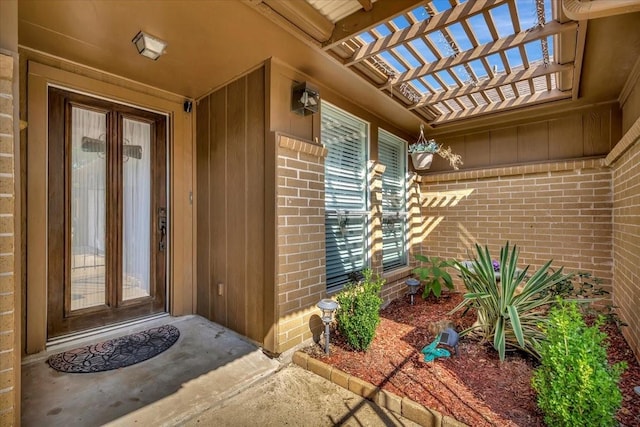 view of exterior entry with a pergola