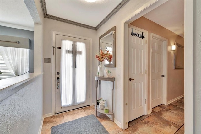 tiled entryway featuring crown molding