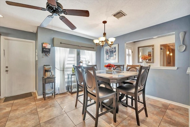 dining space with light tile patterned flooring, ceiling fan with notable chandelier, and a textured ceiling