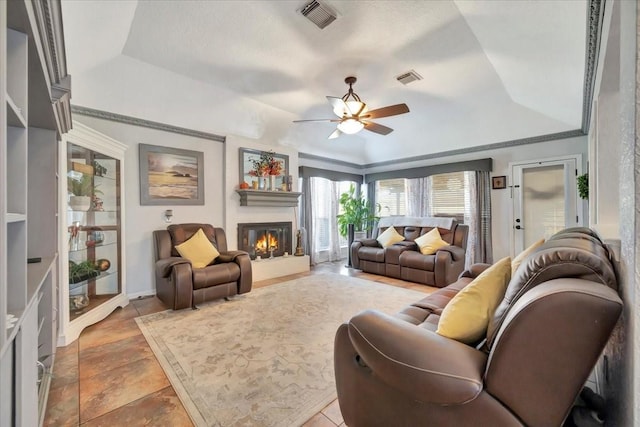 living room featuring ceiling fan, ornamental molding, and a tray ceiling