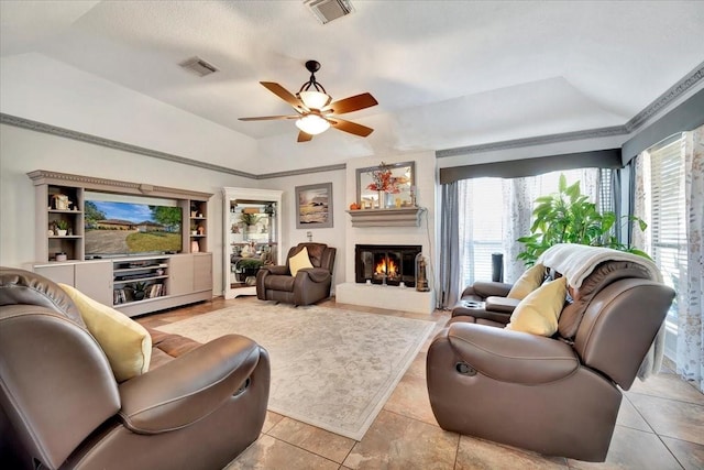 living room with a raised ceiling, lofted ceiling, and ceiling fan