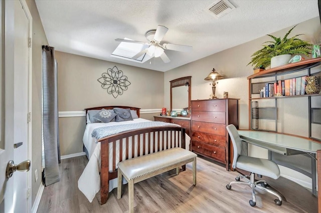 bedroom featuring a textured ceiling and light hardwood / wood-style flooring