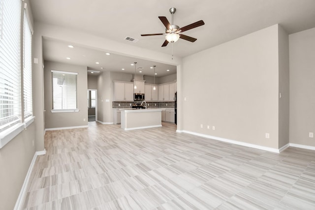 unfurnished living room featuring sink and ceiling fan