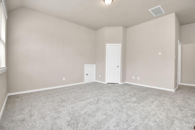 empty room featuring lofted ceiling and carpet flooring