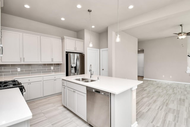 kitchen featuring pendant lighting, an island with sink, sink, white cabinets, and stainless steel appliances