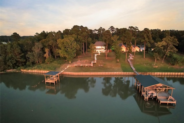 view of dock with a wooded view and a water view