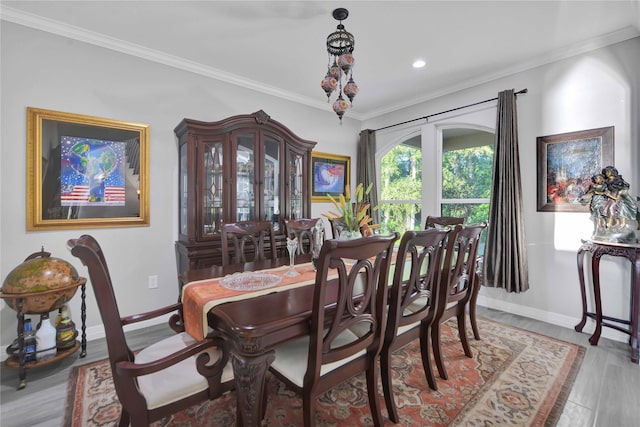 dining area featuring light wood-type flooring, baseboards, and ornamental molding