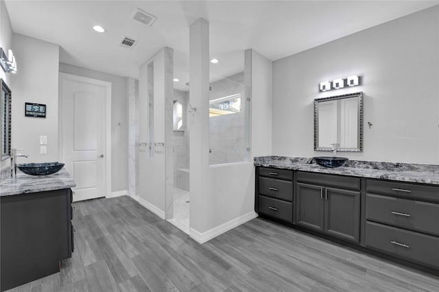 full bathroom with two vanities, visible vents, and a sink