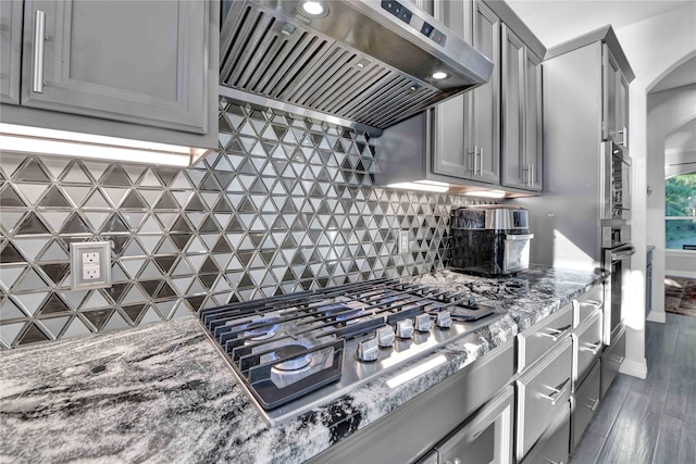 kitchen featuring ventilation hood, tasteful backsplash, appliances with stainless steel finishes, and gray cabinets