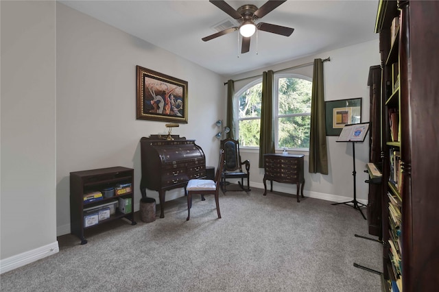 living area with baseboards, carpet, and a ceiling fan