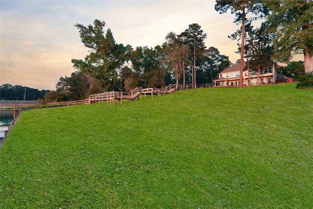 yard at dusk featuring a water view