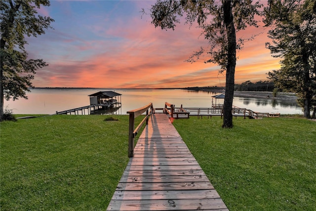 dock area with a water view and a yard