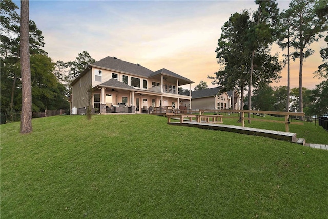 rear view of house with a patio area, a lawn, a ceiling fan, and fence