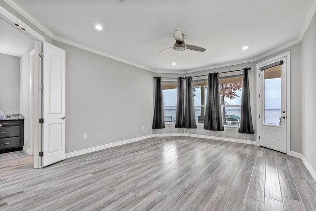 spare room featuring ceiling fan, ornamental molding, and light hardwood / wood-style floors