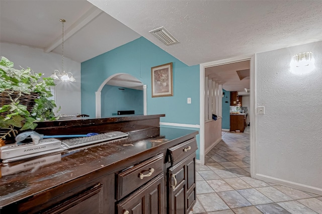 bathroom featuring lofted ceiling, an inviting chandelier, tile patterned floors, and a textured ceiling