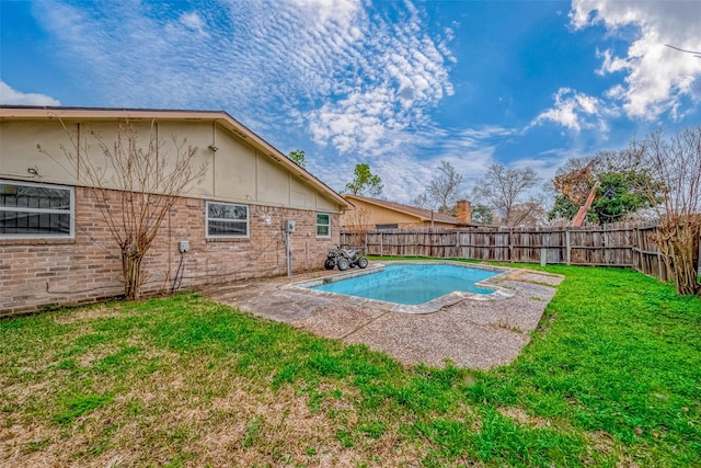 view of pool with a patio area and a lawn