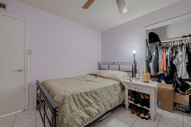 tiled bedroom featuring ceiling fan and a closet