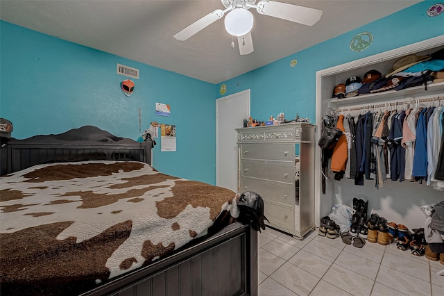 bedroom with light tile patterned floors, a closet, and ceiling fan