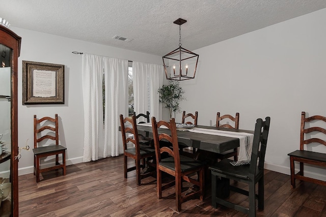 dining room featuring dark hardwood / wood-style floors, an inviting chandelier, and a textured ceiling