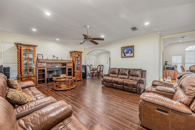 living room featuring crown molding, ceiling fan, and a textured ceiling