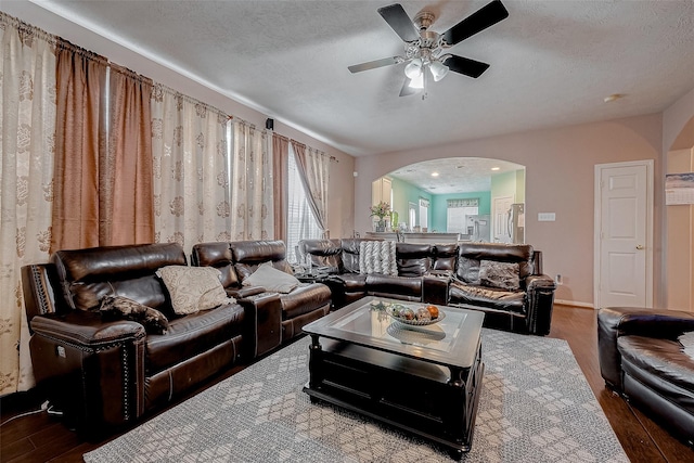 living room featuring ceiling fan, hardwood / wood-style floors, and a textured ceiling