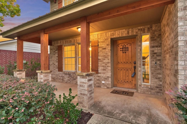 exterior entry at dusk featuring a porch