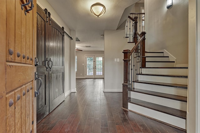 entrance foyer with dark wood-type flooring and a barn door