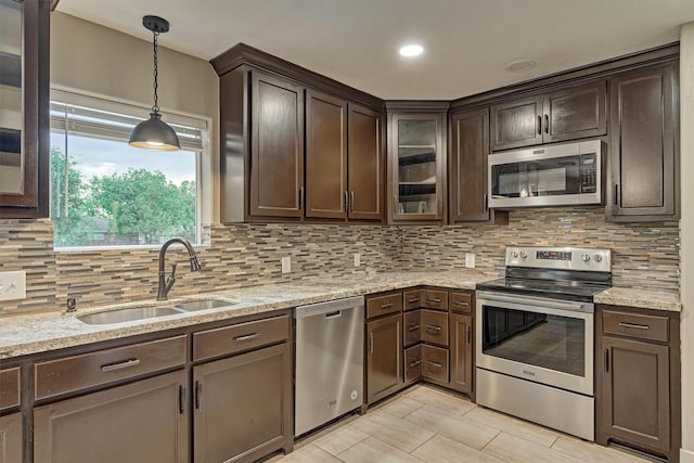 kitchen with sink, decorative light fixtures, dark brown cabinets, and appliances with stainless steel finishes