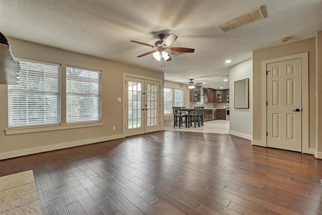 interior space with hardwood / wood-style flooring, ceiling fan, french doors, and a textured ceiling