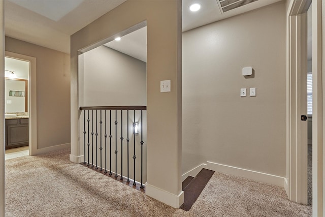 hall with light colored carpet