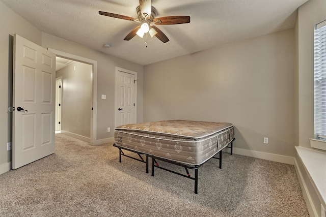 bedroom with a textured ceiling, ceiling fan, and carpet