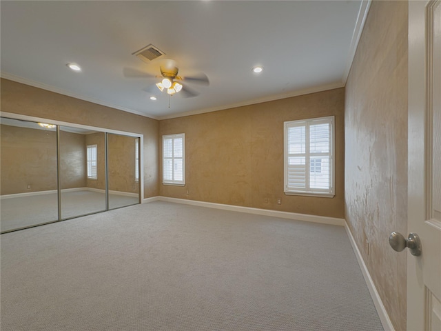 unfurnished bedroom featuring light colored carpet, ornamental molding, a closet, and ceiling fan