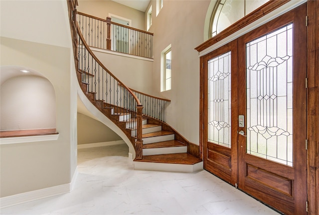 entrance foyer featuring a towering ceiling and french doors